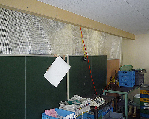 施工前：事務スペースと作業場がカーテンで仕切られている。
